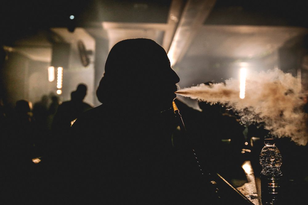 Gast mit Shisha in gedämpftem Licht